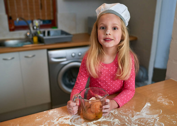 Whats next after the eggs. a little girl baking in the kitchen - Photo, Image