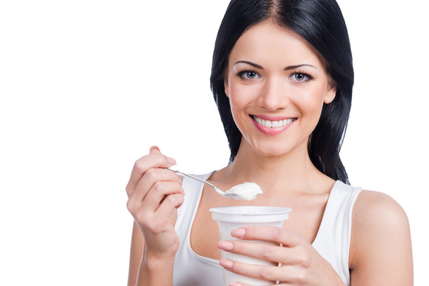 Woman holding  spoon with sour cream - Fotó, kép