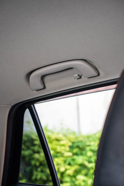 Impugnatura bianca dal sedile posteriore sul soffitto bianco di un'auto giapponese. - Foto, immagini