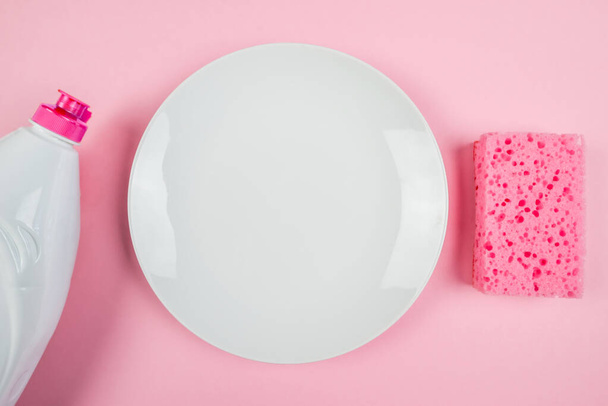 empty white sponge plate and dish detergent bottle on pink background. View from above. - Photo, image