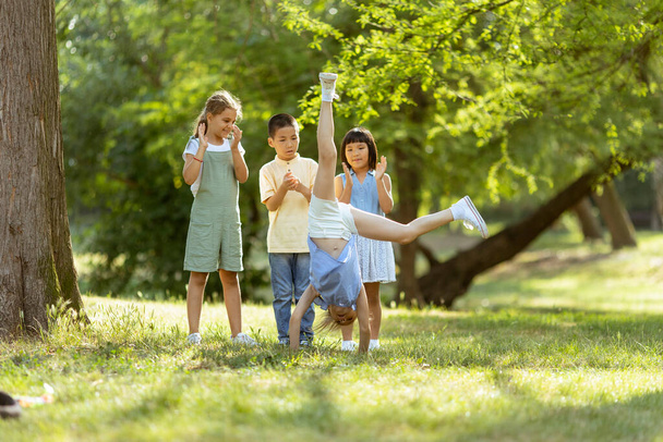 Grupo de lindo asiático y caucásico niños divirtiéndose en el parque - Foto, imagen