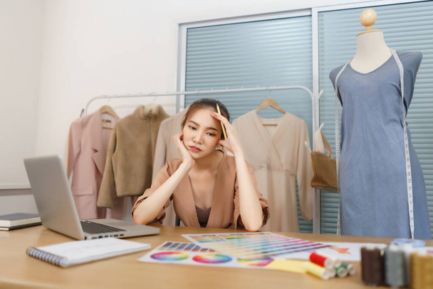 Fashion design concept, designer donna asiatica contemplare mentre si sceglie il colore per la nuova collezione. - Foto, immagini