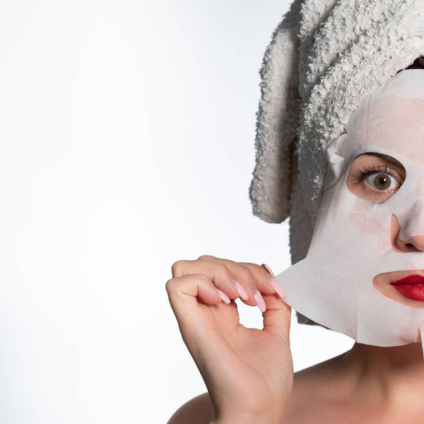 Portrait of a woman with a cotton mask to moisturize her face, place for advertising and inscription. - Foto, imagen