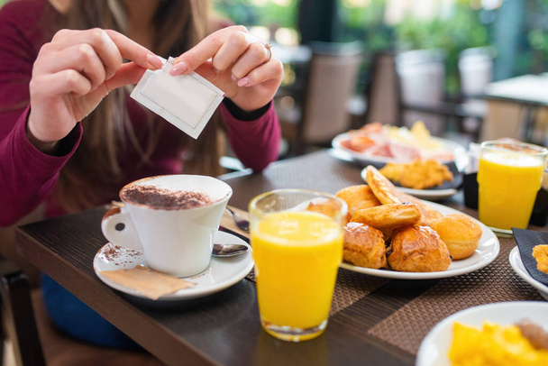 Woman having breakfast with cappuccino, sweet pastries and orange juice - Fotografie, Obrázek