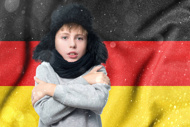 Cold winter and consequences of gas sanctions, consequences of the war in Ukraine, shortage of gas and heat in Germany, a European schoolboy boy is freezing in the winter heating period. - Photo, image