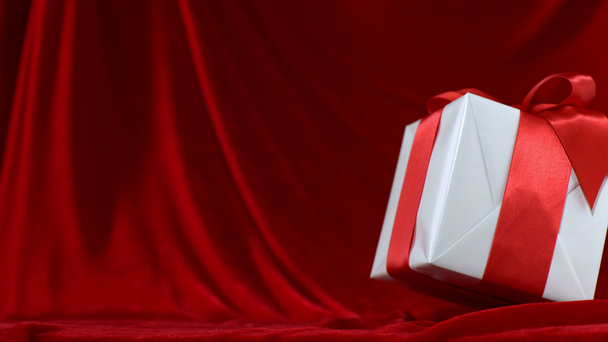 Present falls onto red fabric - Záběry, video