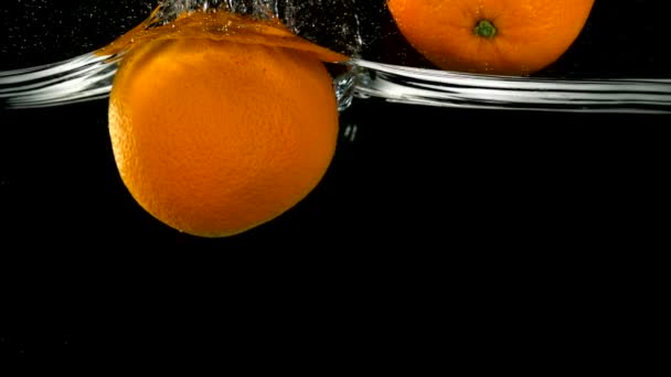 Pomarańcze wpadnięciem do wody - Materiał filmowy, wideo