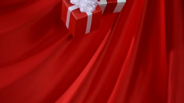 プレゼントは赤い布の上に落下します。 - 映像、動画