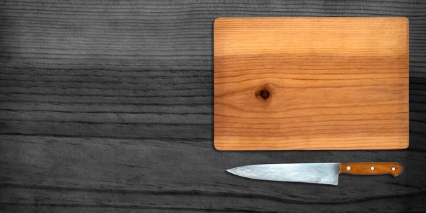 Κάτοψη του Μαγειρική Μαχαίρι και Κοπή Διοικητικό Συμβούλιο σε σκούρο φόντο - Φωτογραφία, εικόνα