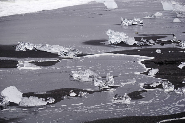 Blocks of ice laying on black volcanic sand - Diamond Beach, Jokulsarlon, Iceland - Φωτογραφία, εικόνα