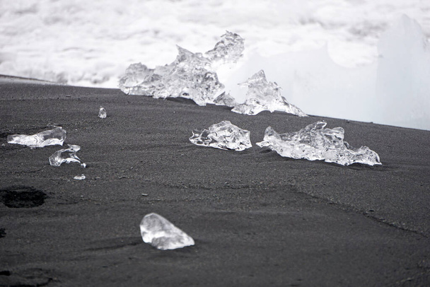 Blocks of ice laying on black volcanic sand - Diamond Beach, Jokulsarlon, Iceland - Foto, Imagem
