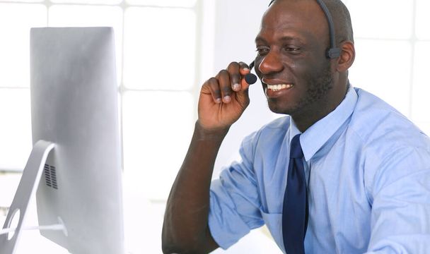 African american businessman on headset working on his laptop. - Foto, immagini