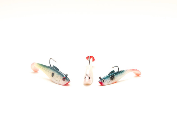 Collection of shad jig head hard bait lures with sharp hook isolated on white background. Plastic lure for striped bass fishing. - Photo, image