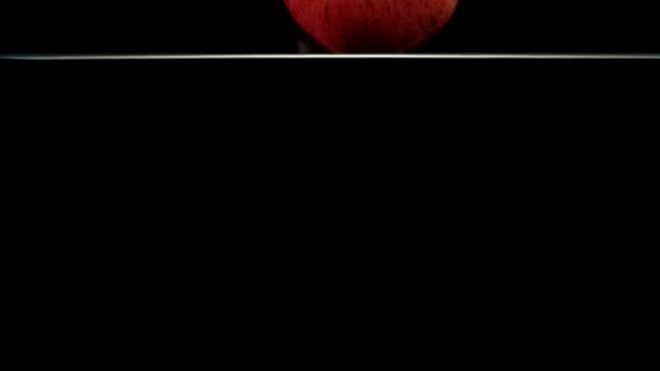 κόκκινο μήλο πέφτει στο νερό - Πλάνα, βίντεο