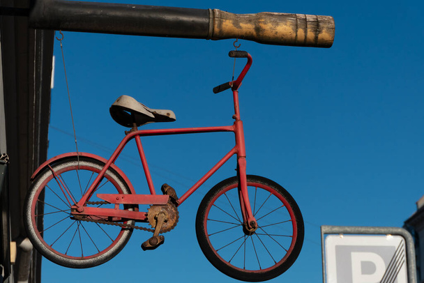 Copenhagen, Denmark,  A bike hanging from a sign at a bike store. - Photo, image