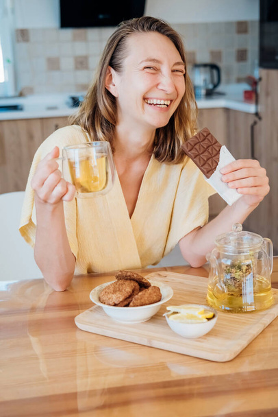Young woman drinks herbal green tea at home in the kitchen - Foto, Bild