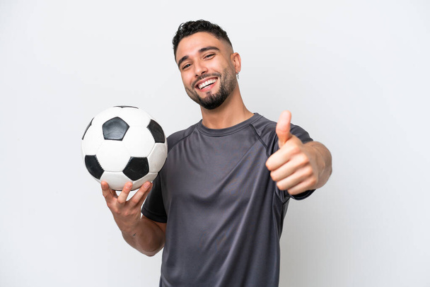 Arabische jonge football speler man geïsoleerd op witte achtergrond met duimen omhoog omdat er iets goeds is gebeurd - Foto, afbeelding