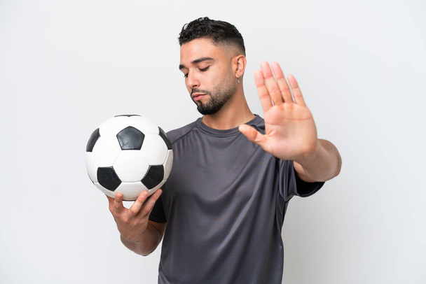 Arab young football player man isolated on white background making stop gesture and disappointed - Foto, afbeelding