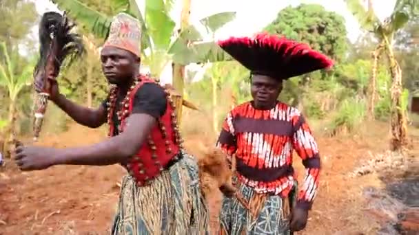 Два африканских танцора танцуют в традиционной одежде во время племенного мероприятия - Кадры, видео