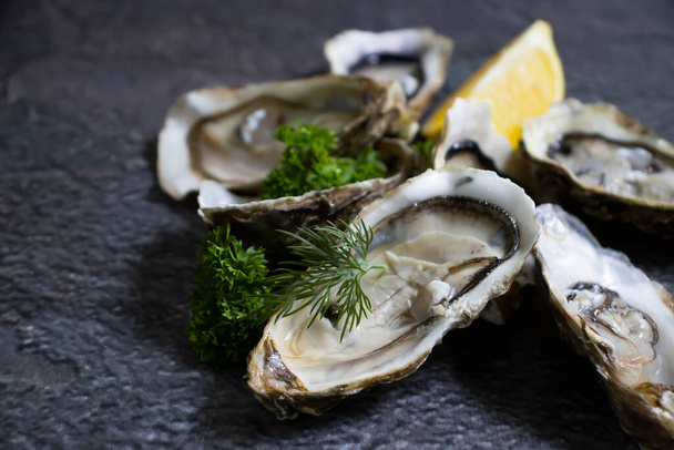 Oysters with lemon on old background - Fotó, kép