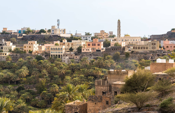 Blick auf das Bergdorf Misfat Al Abriyeen, umgeben vom Garten mit Dattelpalmen, Sultanat Oman - Foto, Bild