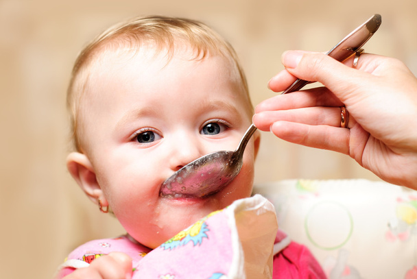 Girl eating from spoon - Φωτογραφία, εικόνα