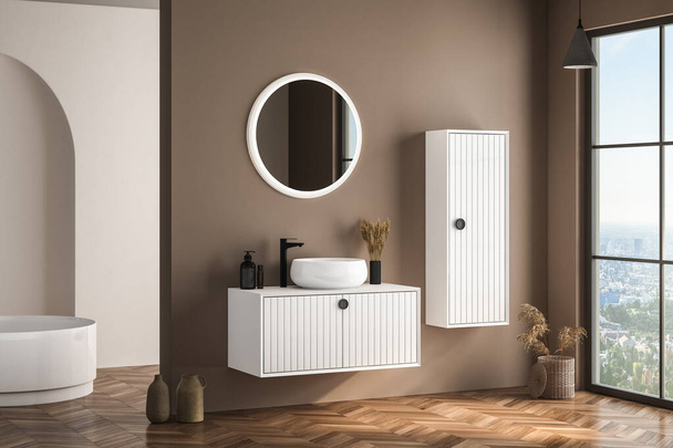 Modern bathroom interior with beige walls, white basin with oval mirror, bathtub and parquet floor. Minimalist beige bathroom with modern furniture. 3D rendering - Foto, Imagem