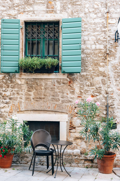 Window with green shutters and table of the street cafe in Sibenik, Croatia. - Foto, Imagem
