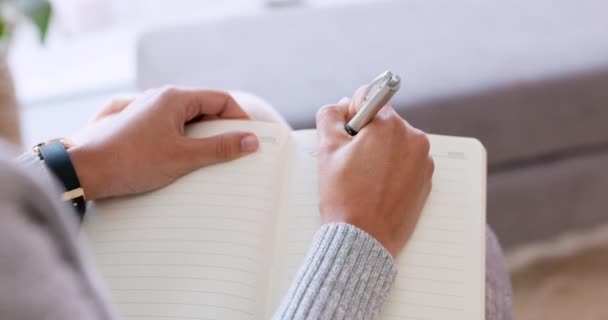 Woman hands writing in notebook, journal or diary with a pen and sitting on sofa while relaxing at home on the weekend. Female freelance writer relax and write a rough draft or sample in a book. - Video, Çekim