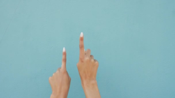 Fingers pointing to advertising and marketing space or mock up on blue wall background. Number one or index finger showing important message, information sign or gesture with mockup studio background. - Video