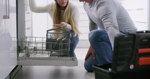 Angry couple conflict, fight while repair dishwasher in kitchen at home, annoyed and frustrated. Upset husband and wife argue, blame and discuss fault, unhappy and stressed, fighting marriage problem. - Кадры, видео