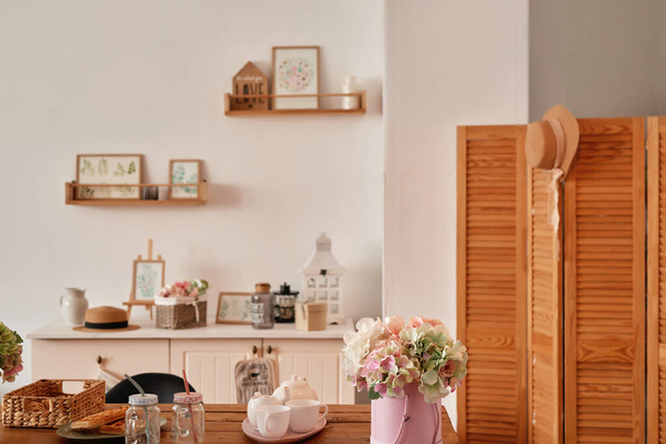 White kitchen interior in loft style. Shelves with pink crockery and kitchen utensils. Studio apartment. Rent and delivery of housing. Hostel and hotel. - Photo, Image