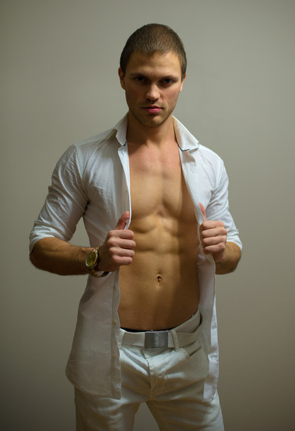 muskulöses männliches Modell posiert auf grauem Hintergrund. - Foto, Bild