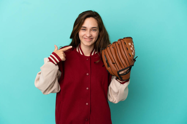Junge kaukasische Frau spielt Baseball isoliert auf blauem Hintergrund und gibt eine Daumen-hoch-Geste - Foto, Bild