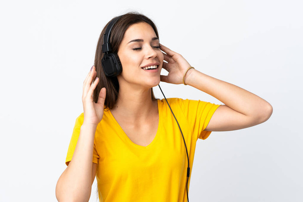 Giovane donna caucasica isolata su sfondo bianco ascoltare musica e cantare - Foto, immagini