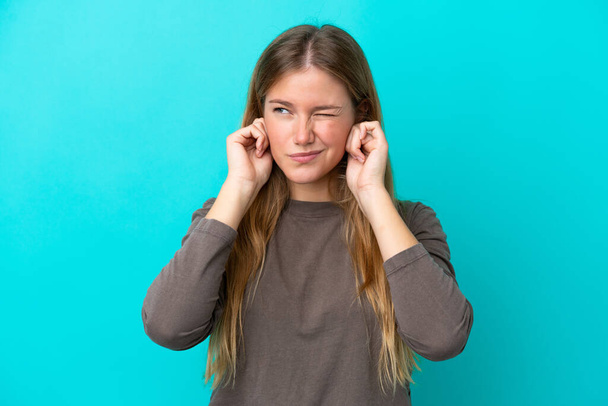 Young blonde woman isolated on blue background frustrated and covering ears - Fotoğraf, Görsel