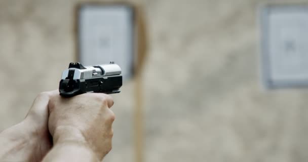 Pistol shooting bullets in slow motion footage. Hand guns in shooting range - Filmati, video