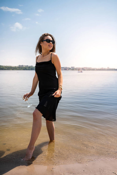 mooie vrouw op blote voeten wandelingen door het meer, warm water, ontspanning en rust - Foto, afbeelding