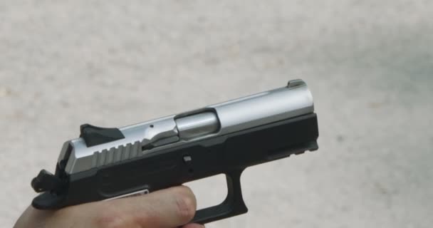 Pistol shooting bullets in slow motion footage. Hand guns in shooting range - 映像、動画