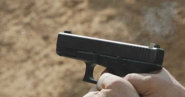 Slow motion of a hand gun firing with cartridge flying away - Záběry, video