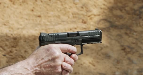 Slow motion of a hand gun firing with cartridge flying away - Séquence, vidéo