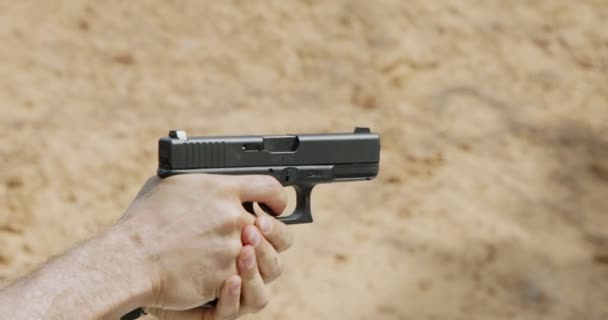 Slow motion of a hand gun firing with cartridge flying away - Materiaali, video