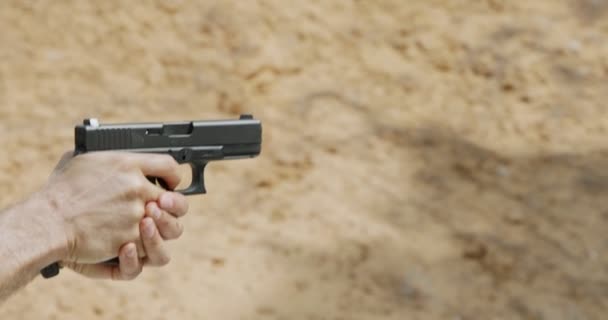 Slow motion of a hand gun firing with cartridge flying away - Video, Çekim