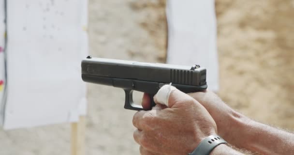 Slow motion close up shot of a man shooting a hand gun while moving - Imágenes, Vídeo