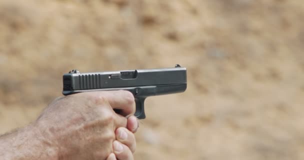 hand gun firing with cartridge flying away - Кадры, видео