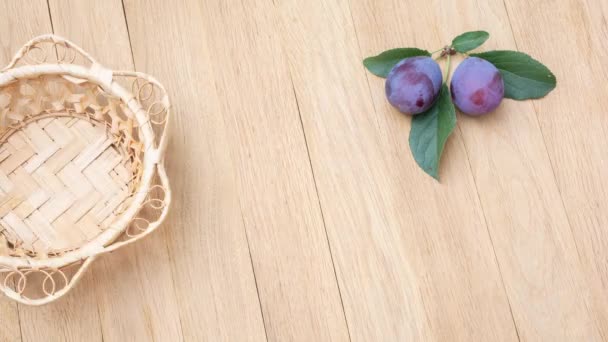 A wicker plate appears on a wooden table and is then filled with ripe plums. Stop motion animation - Materiaali, video