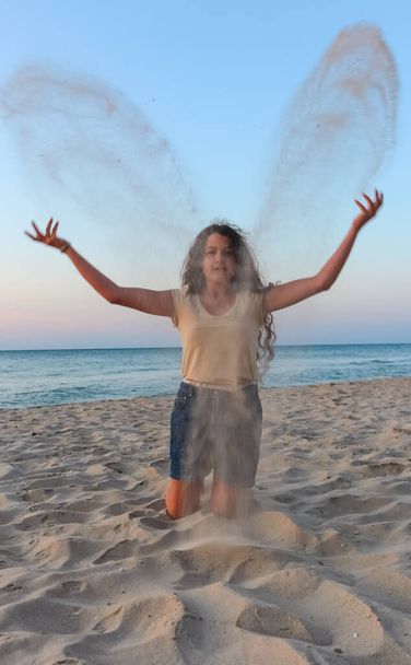 girl teenager plays sand on the Black Sea beach, summer vacatio - Foto, afbeelding