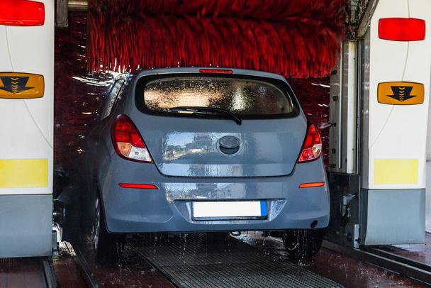 Automatic car wash. Auto brush washer clean blue car on automatic carwash station. Automatic car wash cleaning service - Foto, immagini