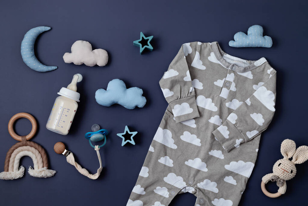 Flat lay with baby sleep accessories with milk bottles, pacifier, pajamas and toys. Newborn sleeping rules concept - Foto, Bild