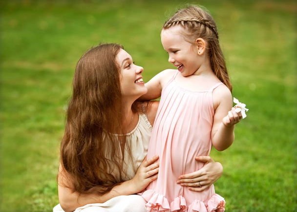 Mother and daughter hugging in love playing in the park - 写真・画像
